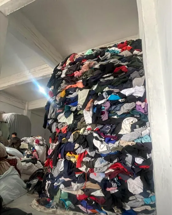 A mountain of second-hand clothing our team sorts through by hand