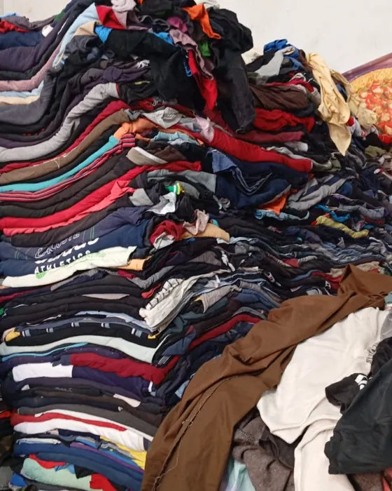 A mountain of second-hand clothing our team sorts through by hand