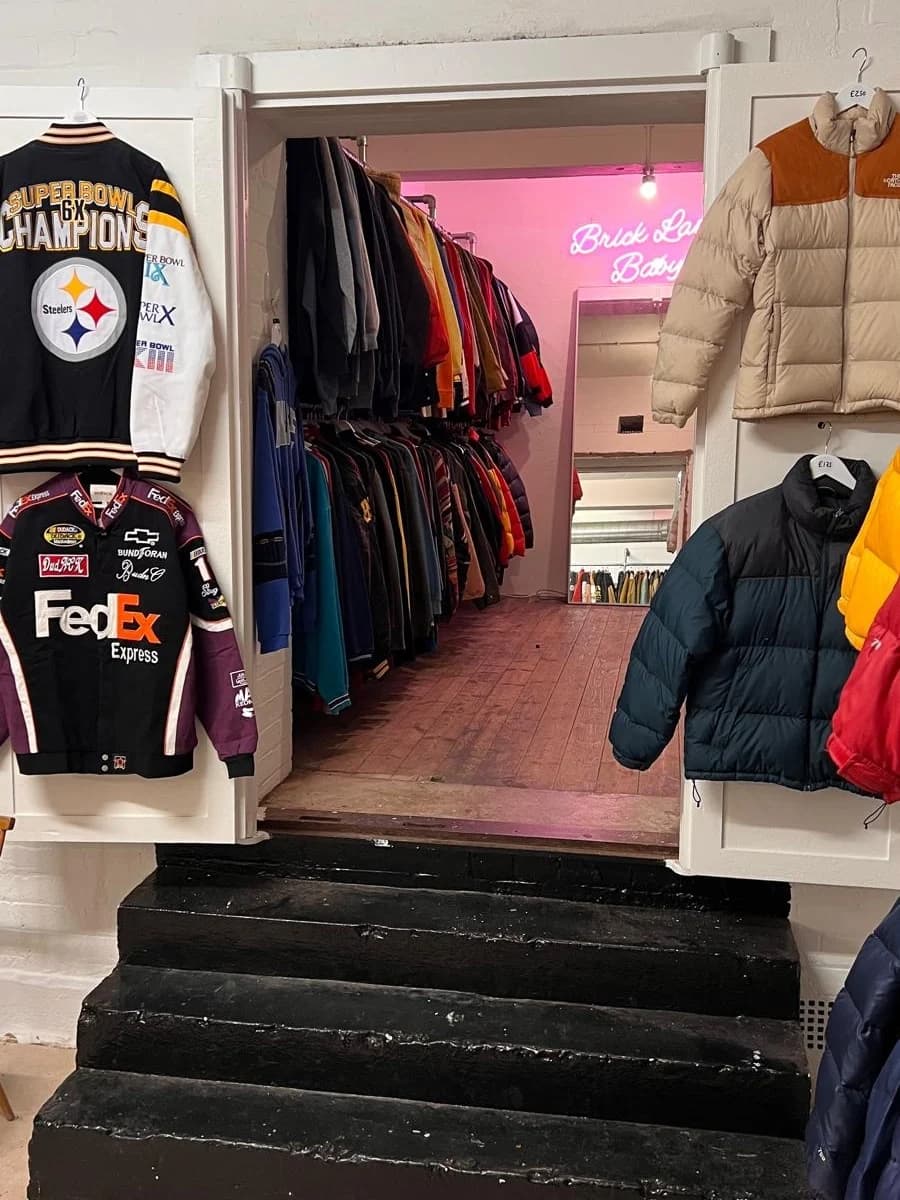 Steps up into a back room of rails, jackets hung on the doors