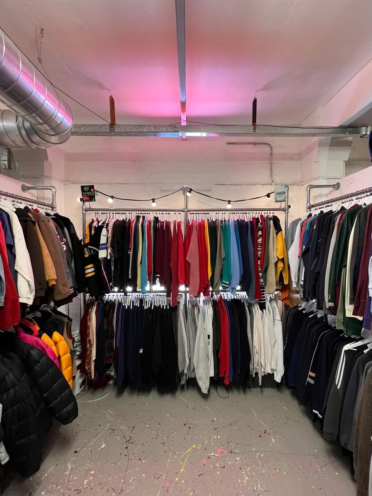 One of our London shops: rails of vintage sweatshirts and jackets under string lights