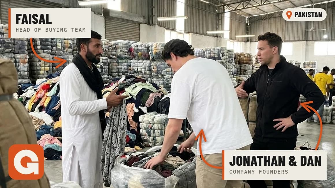 Faisal, head of our buying team, sorting a bale of used clothing with founders Jonathan and Dan in our warehouse in Pakistan